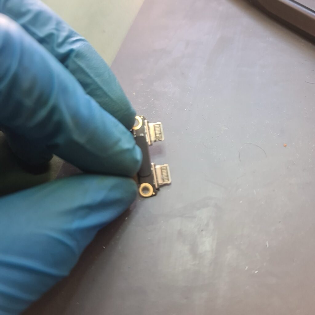 Close-up of the removed dual USB-C charging port assembly from a 2020 MacBook Air that was not turning on or charging.