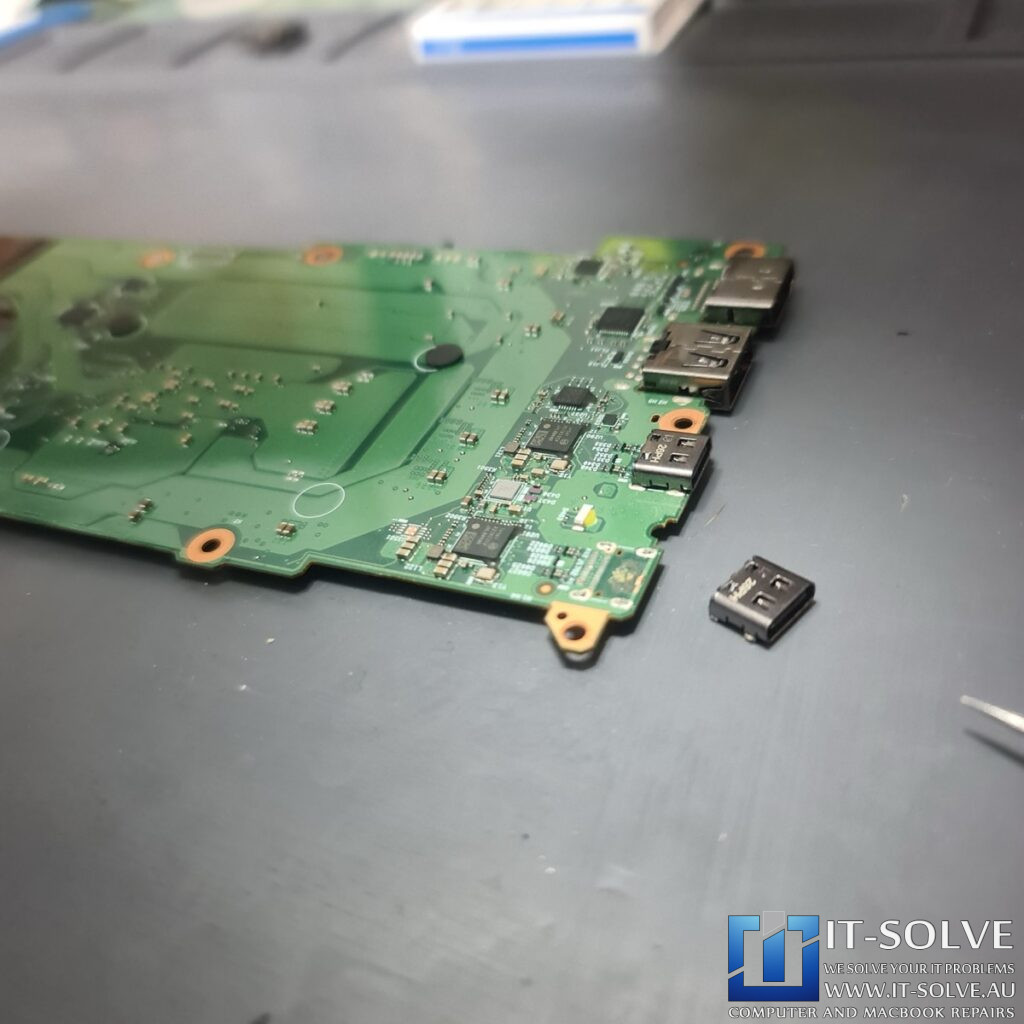 Photo of the logic board removed, showing the underside of the USB-C port area