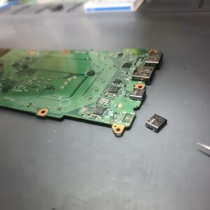 Photo of the logic board removed, showing the underside of the USB-C port area