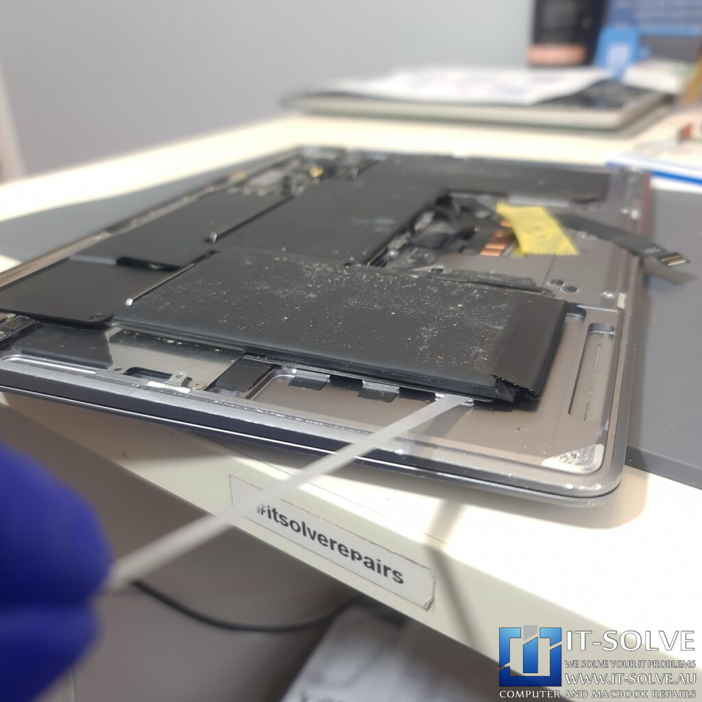 process of prying the battery out of the case of A2337 Macbook Air