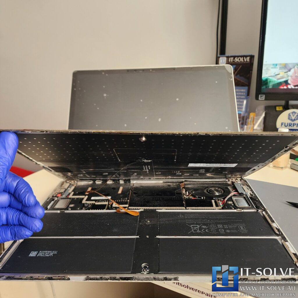 Photo showing the removed palmrest and heatsink with the motherboard exposed